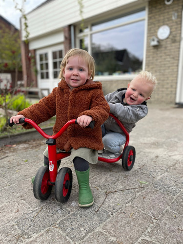 Kinderen spelen buiten op de loopfiets
